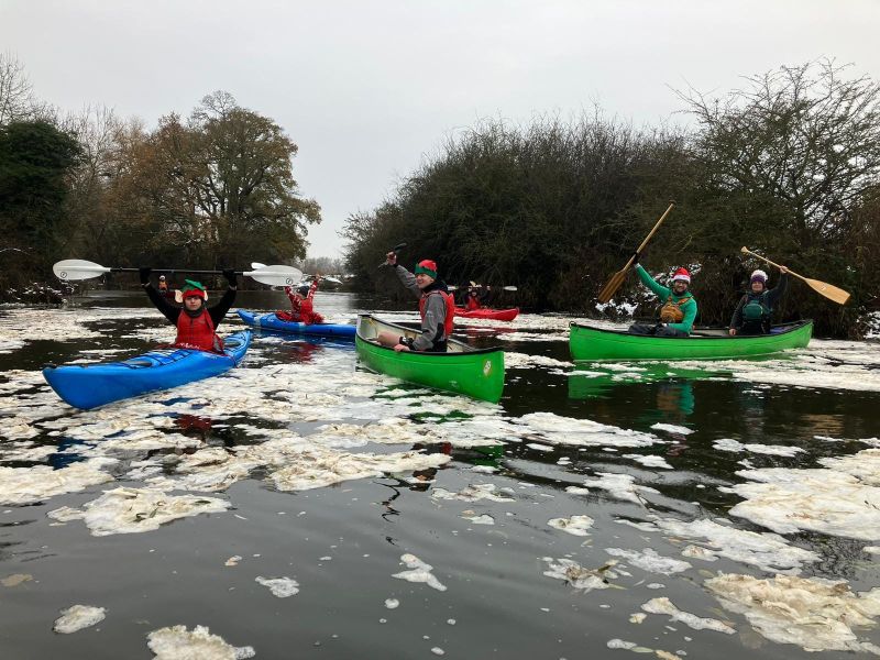 Blue kayak and green canoe on icy water