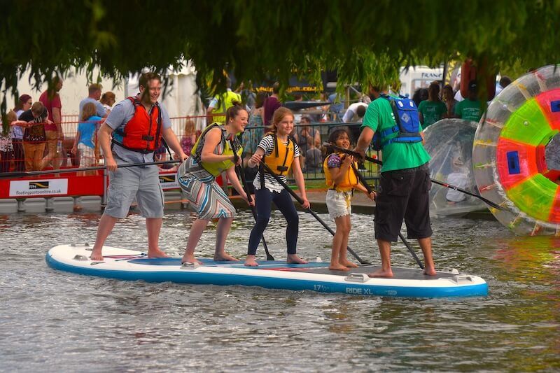 Kids jumping into water from paddleboard