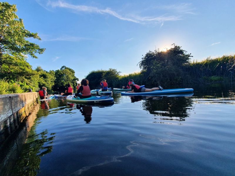 Group relaxing in evening on hired paddle boards
